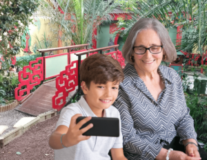 Mamie et son petit-fils qui se prennent en photo devant un décor asiatique